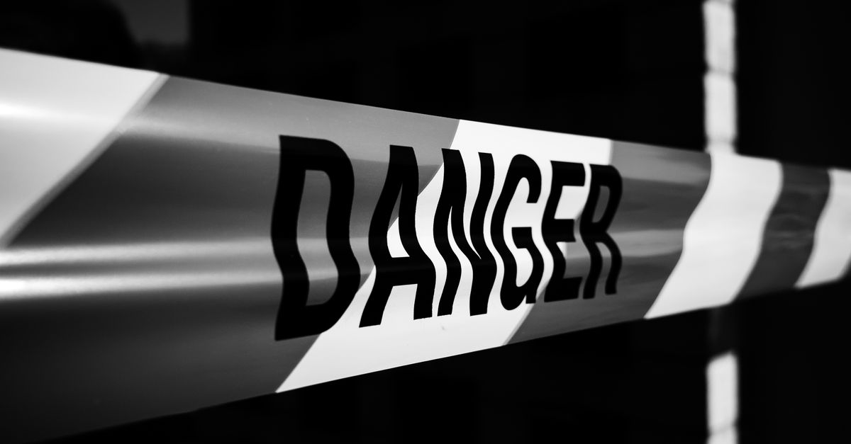 Close-up of a danger tape in black and white, emphasizing caution and warning.
